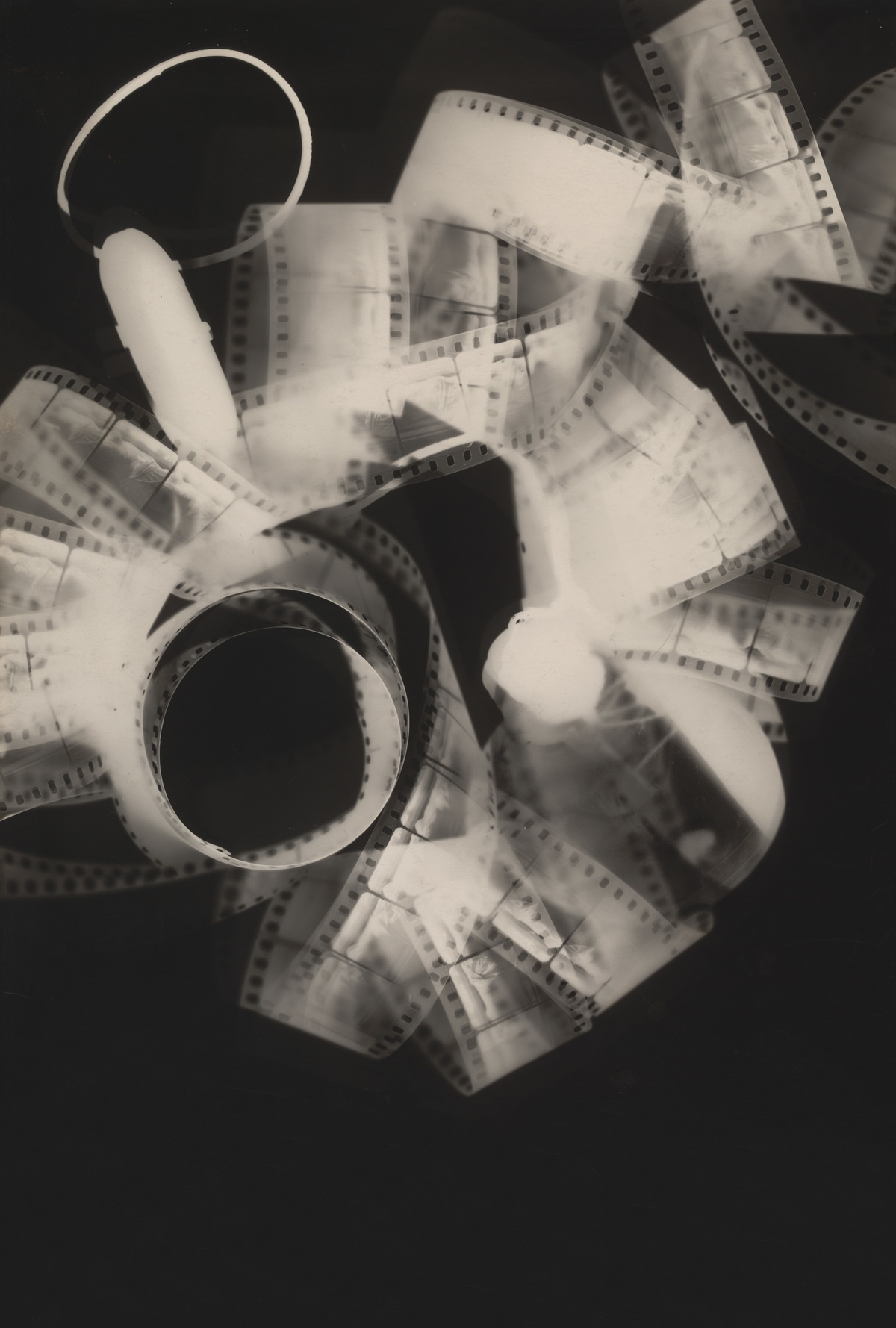 Curling strips of photographic film and overlapping translucent shapes form a dense monochrome composition.