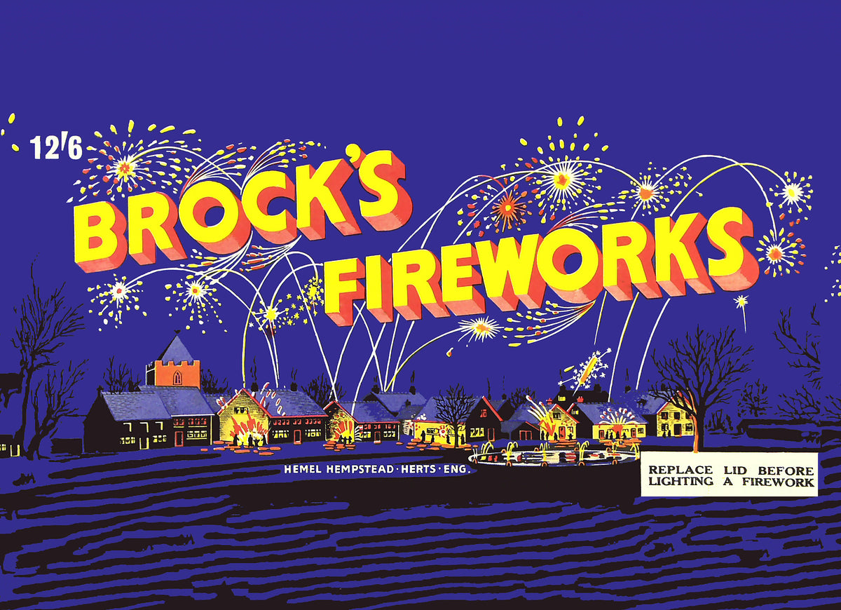 Yellow and red lettering arcs above a village lit by colourful fireworks against a deep blue evening sky.