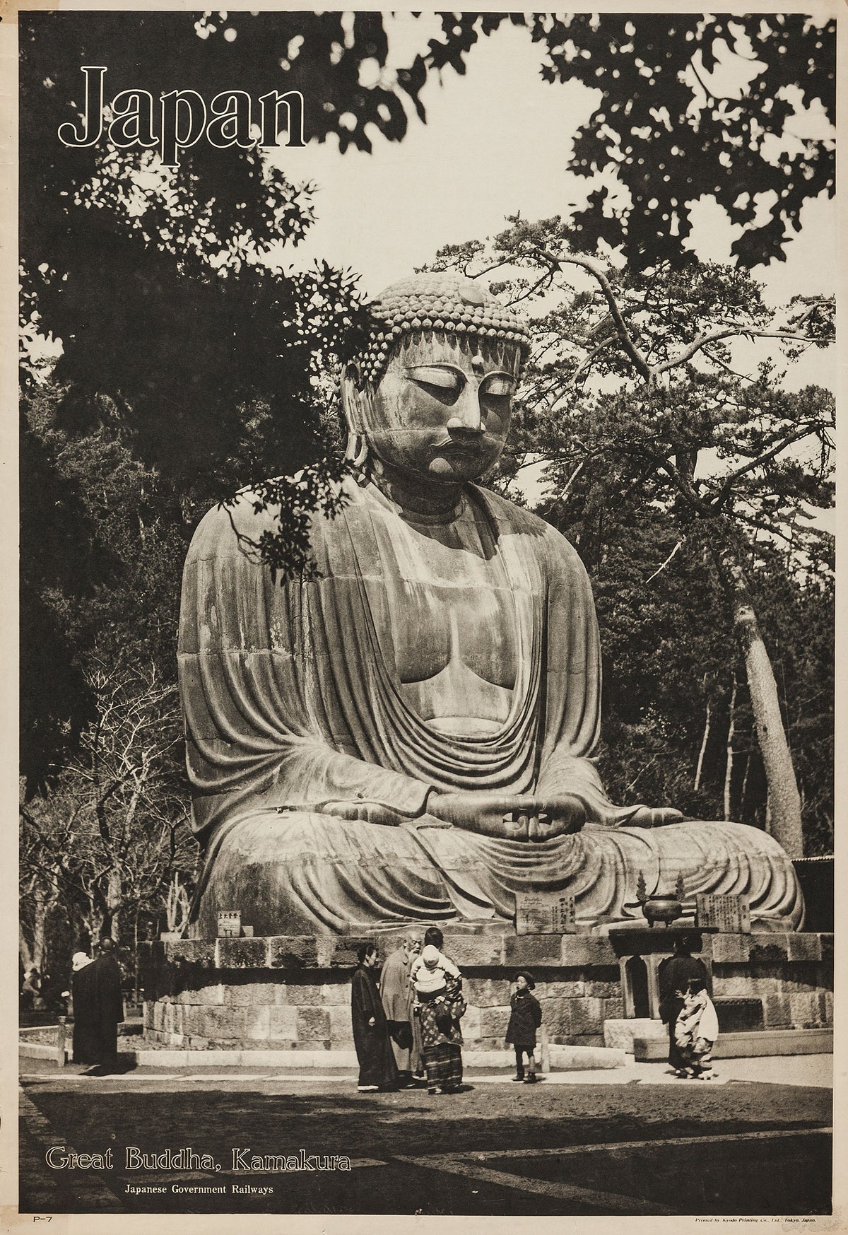 A monochrome view of the seated Great Buddha at Kamakura, framed by trees with visitors gathered near the base.