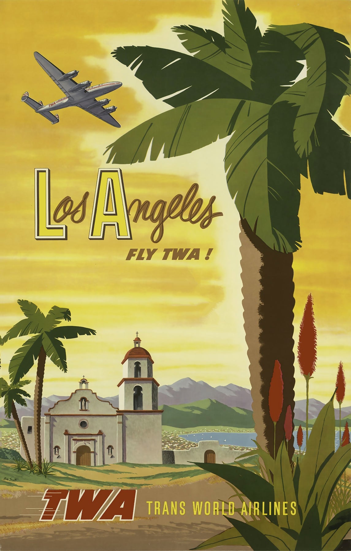 A silver aircraft passes above palm trees, a white mission building and distant hills under a yellow sky.