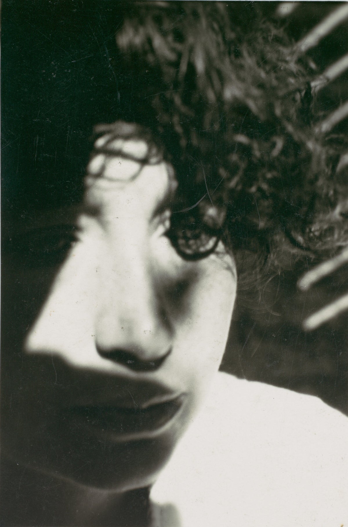 Close-up black and white portrait of Lucia Moholy with dramatic shadows.