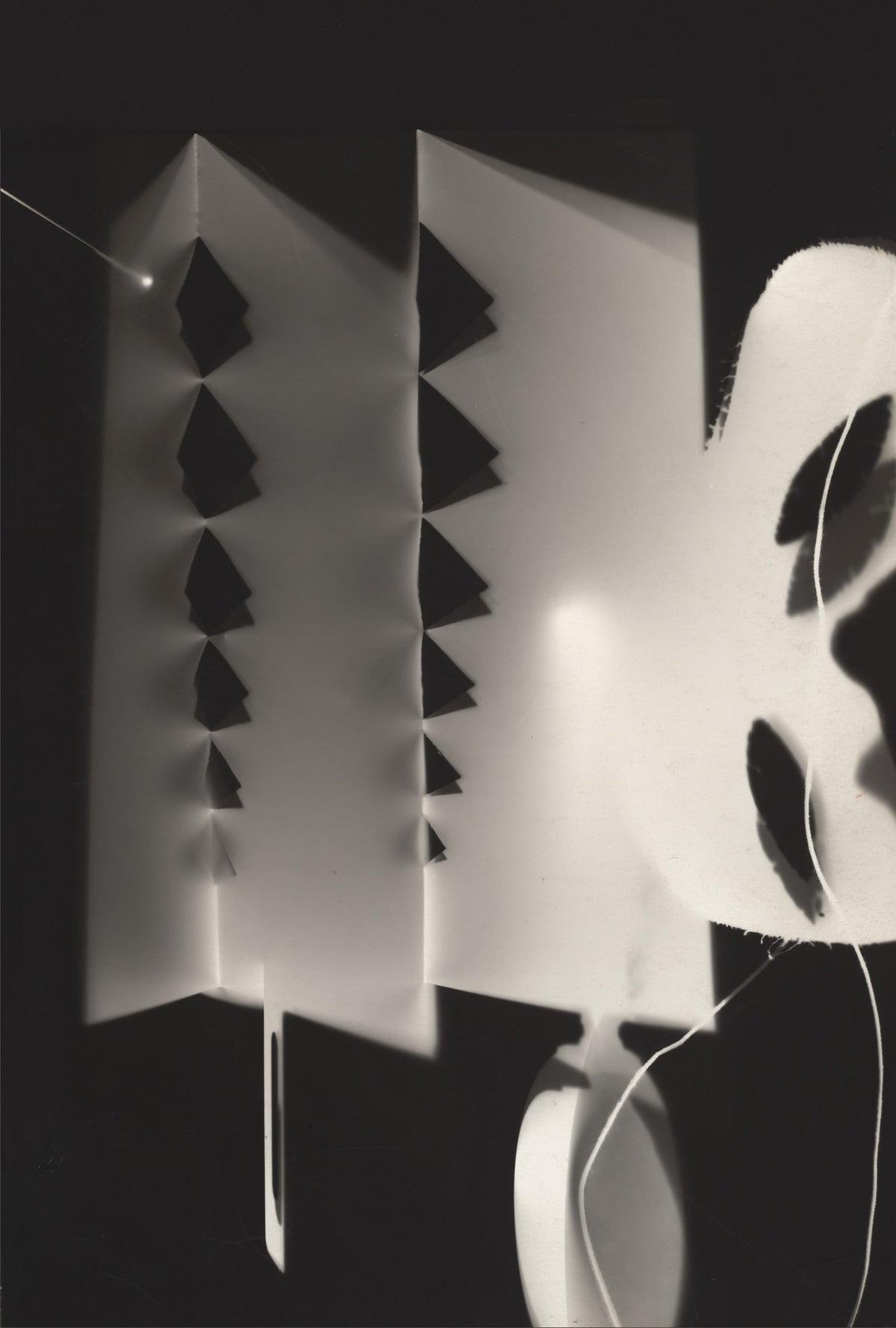 Folded pale panels with dark triangular cut-outs overlap delicate lines and a large curved white form.